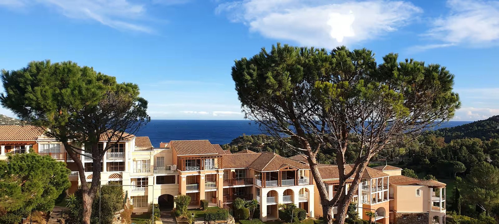 Les bâtiments du domaine de Cap Estérel, leurs pins parasols et la Méditerranée