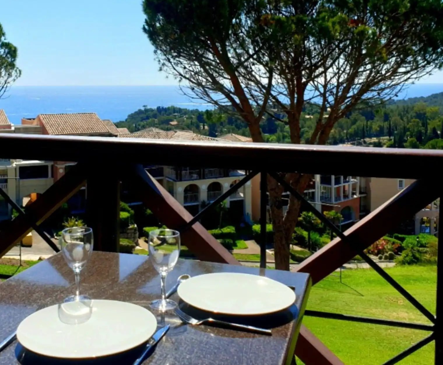 La table dressée sur la terrasse couverte du T2 d'Agay, face à la mer et aux pins parasols