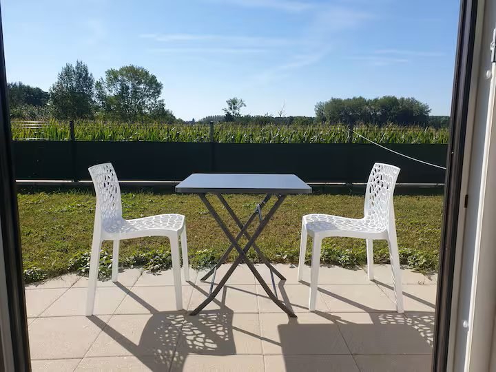 La terrasse privative du studio d'Osthouse, sa table et ses chaises face aux champs